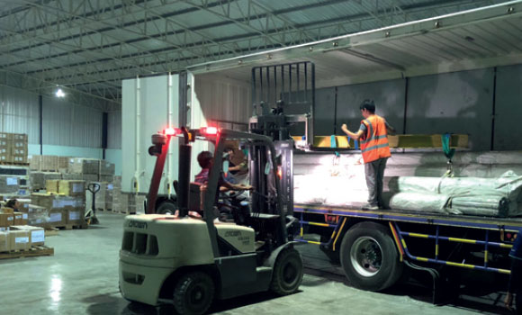 unloading trailer with fork lift inside FPT Global warehouse